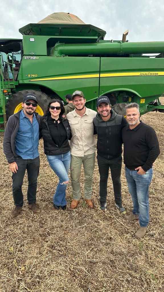 Profissionais em área de produção com máquina agrícola