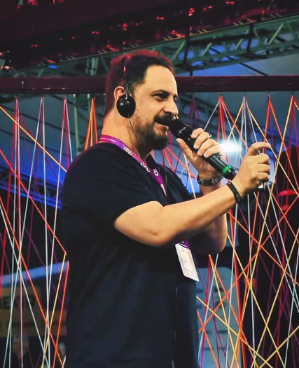 Danilo Pinheiro com microfone em evento corporativo